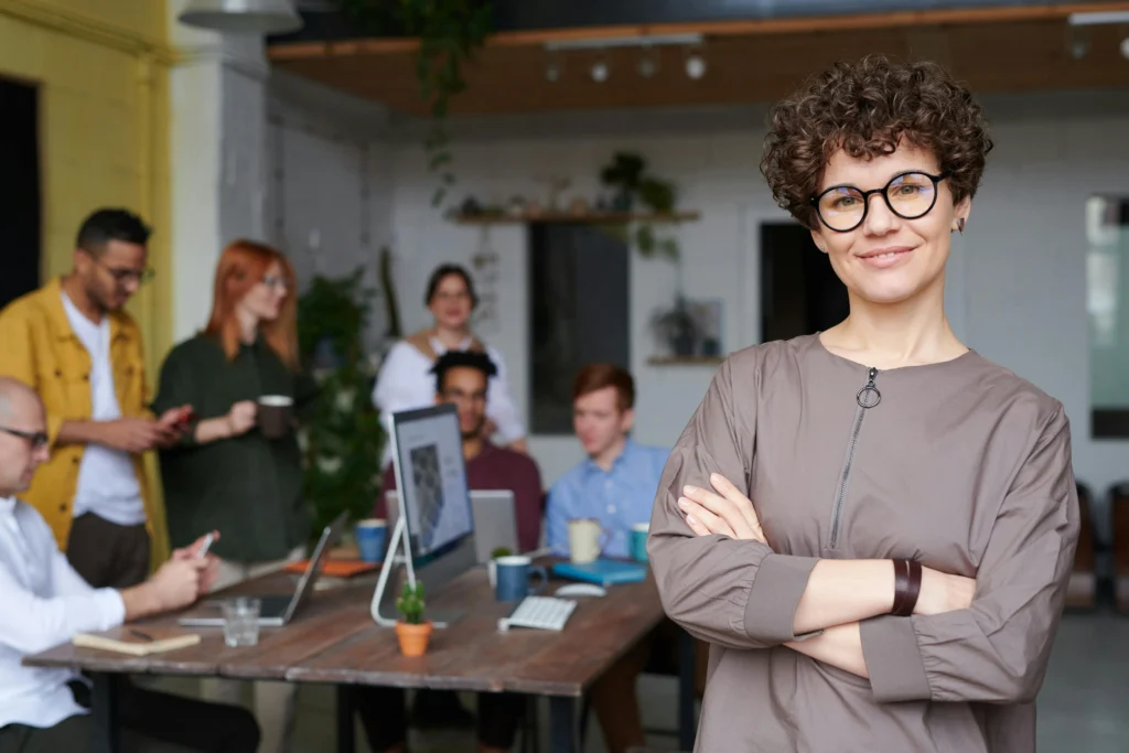 Femme souriante au premier plan et groupe derrière