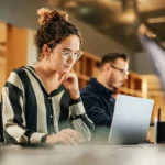 Femme face à son PC dans un cadre de travail